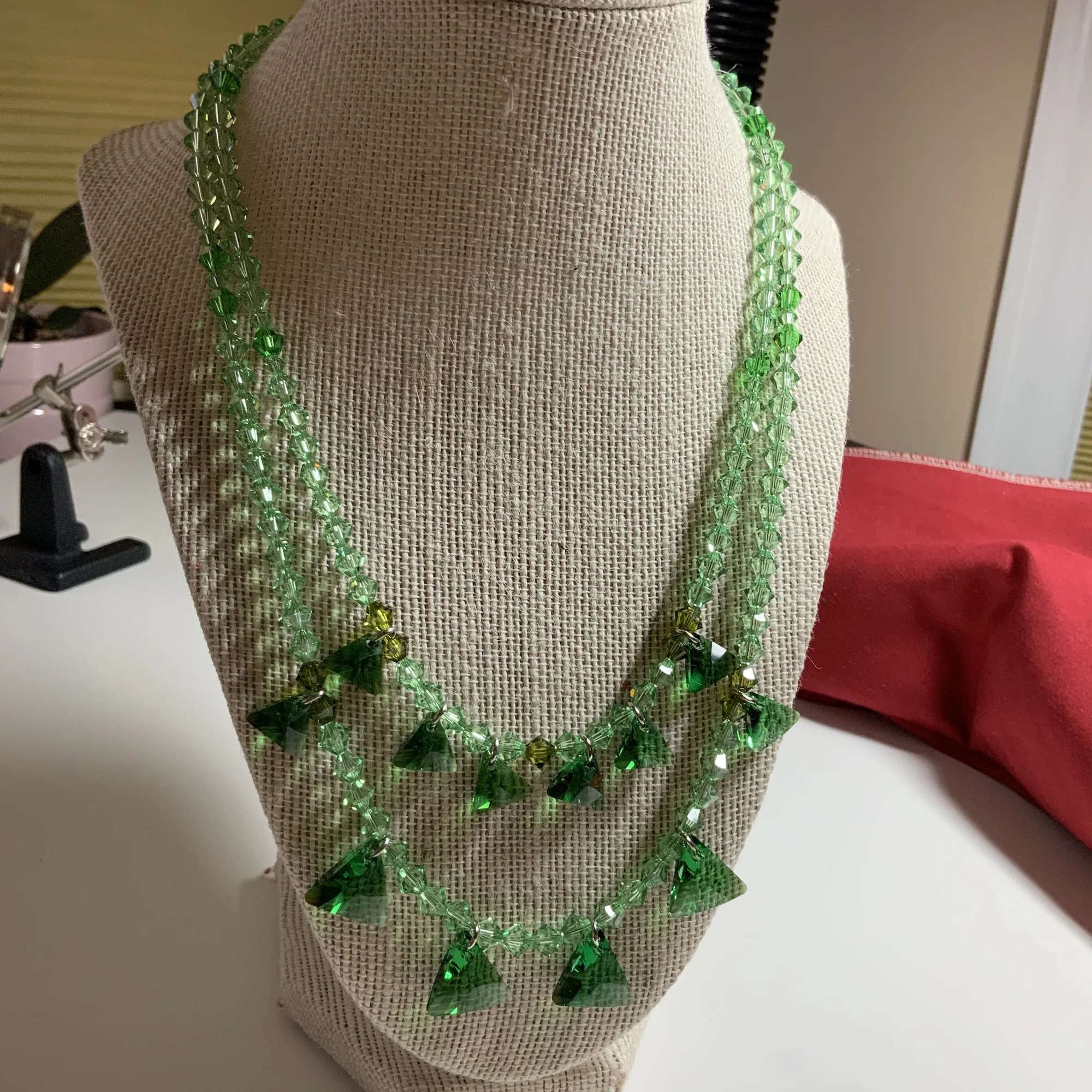 Green gemstone necklace on a display bust